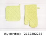 Oven mitt and potholder on white wooden table. Kitchen accessory. Cooking mitten, oven-glove. Flat lay.