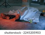 Small photo of Dead body of a man is on the ground, covered in white cloth. Conception of murder, homicide.