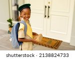 Small photo of Smiling african american scout girl in uniform delivering package at home. unaltered, girl scout, childhood, courage, leadership, delivery and scouting.