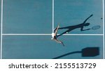 Small photo of Overhead view of african american young female player serving on blue tennis court during sunny day. unaltered, sport, competition and tennis game concept.