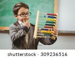 Pupil dressed up as teacher holding abacus in a classroom