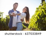 Portrait of young couple dancing at vineyard during sunny day