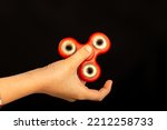 Child's hand playing with a fidget spinner toy
