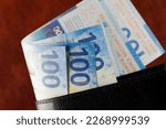 Small photo of The bills slid out of the wallet. Swiss franc notes can be used as illustrations for various financial topics. CHF paper money, edition of Swiss banknotes, issued from April 2016 to 2019.