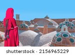 Small photo of Girl in red traditional clothes - Scenic view of domes with convex glasses on roof of Sultan Amir Ahmad Bathhouse (hamam) - Kashan, Iran