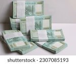Small photo of Stacks of Lebanese pounds, 100,000 denomination, symbolizing the downfall of the Lebanese currency.