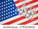 Small photo of syringe with a vaccine is held by hand in a glove on background of the USA flag, vaccine against coronavirus, Operation Warp Speed