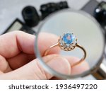 Small photo of jeweler looking at ring with blue stone, jewerly inspect and verify, pawnshop concept, jewerly shop, closeup