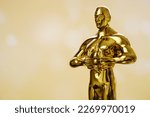 Small photo of Hollywood Golden Oscar Academy award statue on golden background. Success and victory concept.