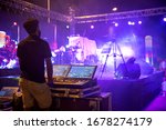 Sound engineer team working to prepare for music concert stage. Hand adjusting audio mixer. DJ for work at a concert in front of the stages