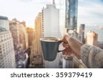 Man holding coffee cup in luxury penthouse apartments with view to New York City Manhattan downtown at the morning