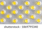 Small photo of Small yellow round pills in silver bluster, macro