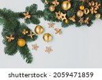 Christmas wreath on blue table, top view. Modern christmas wreath with gold candles, green branches and golden stars on blue background. Winter holiday advent time.