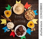 Small photo of Festa Junina Summer Festival Carnival concept. Brazilian straw hat, popcorn, peanuts and colorful flags on wooden background, top view. Design for Greeting Card, Invitation or Holiday Poster
