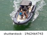 Angled overhead view of an open pontoon motor boat cruising a high speed on Biscayne Bay near Miami Beach,Florida.