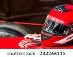 Red helmet with gloves for riding on a racing car