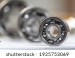 Small photo of Three various ball bearings lying on table. Automotive spare part sale company. Heavy industry engineering company. Machinery designing and manufacturing. Steel details for engine mechanisms.