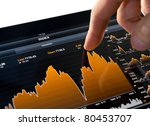 Touching stock market graph on a touch screen device. Trading on stock market concept. Closeup photo.
