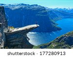 Man tourist on summer Trolltunga (The Troll's tongue) in Odda ( Ringedalsvatnet lake, Norway). Beautiful natural vacation hiking walking travel to nature destinations concept.