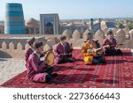 Small photo of KHIVA, UZBEKISTAN - SEPTEMBER 06, 2022: A collective of Uzbek folk music performers on the roof of the bastion of the Kunya-Ark fortress