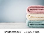 Stack of bath towels on light wooden background closeup