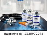 Small photo of Bottles of vaccine for Influenza Virus, Respiratory Syncytial virus and Covid-19 for vaccination. Flu, RSV and Sars-cov-2 Coronavirus vaccine vials over Radiography pulmonar with stethoscope