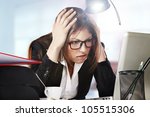 A young business woman is looking stressed as she works at her computer