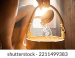 Small photo of pouring water out of a wooden bucket in the Finnish sauna, spa and Warm temperature bath therapy concept image.