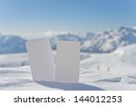 Small photo of Two blank winter sport ski pass tickets with scenic background. Concept to illustrate winter sport admission fee