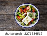 Small photo of Fresh vegetable salad with feta cheese on wooden table