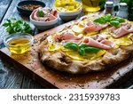 Small photo of Mortadella and potato pizza on wooden table