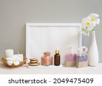 Mockup frame spa wellness concept,golden zen stone,white candle,handmade soap,salt,towel,flowers on wood tray cement wall background