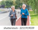 Cheerful active senior couple jogging together outdoors along the river. Healthy activities for elderly people. BeH3althy