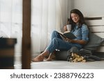 Handsome young woman reading a...