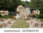 Creative gender neutral baby shower or birthday decoration in the garden. Bohemian style outdoor event set up with balloons. 