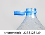 Small photo of Close up of new cap attached to plastic bottle, connected to the neck of the bottle by solid tab attached to safety ring. They are intended to encourage recycling, as part of the fight against litter.