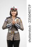 Small photo of Jakarta, Indonesia - August 25th 2023: A beautiful Indonesian police woman with uniform smiling polite hand gesture in white background