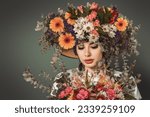 Small photo of Beautiful young woman adorned with a big hat beautifully decorated with flowers. An epitome of floral elegance and grace.