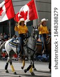 Small photo of CALGARY, CANADA - JUL 9, 2004 - Yellow women riders with Canadian flags on horseback,Calgary Stampede Parade, Alberta, Canada