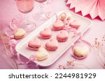 Happy Mothers Day, Happy Valentine - sweet macarons in heart shape and glasses of rose sparkling wine in pink tone