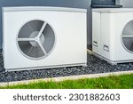 Small photo of Two air source heat pumps installed outside of new and modern city house, green renewable energy concept of heat pump