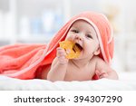 Cute baby with teether under a hooded towel after bath
