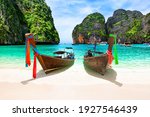 Beautiful beach with thai traditional wooden longtail boat and blue sky in Maya bay, Thailand. Vacation holidays summer background. View of nice tropical beach in Maya bay near Phuket in Thailand.