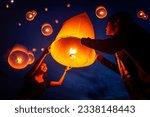 Small photo of Asian couple traveller setting yi peng lantern in loi krathong festivities celebration in chiang mai, Thailand