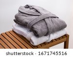 grey and white bath robes on wooden bench