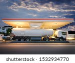 Tanker gas truck delivering fuel at service station against dramatic night sky