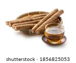 Small photo of Burdock tea on a white background. A raw burdock behind it