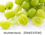 A lot of Shine-Muscat grapes and cut Shine-Muscat grapes on a white background. White grapes.  Japanese grapes. 