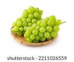 Shine Muscat in a bamboo colander on a white background. White grapes. Japanese grapes.