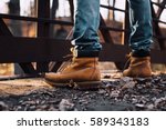 man wearing boots standing on bridge